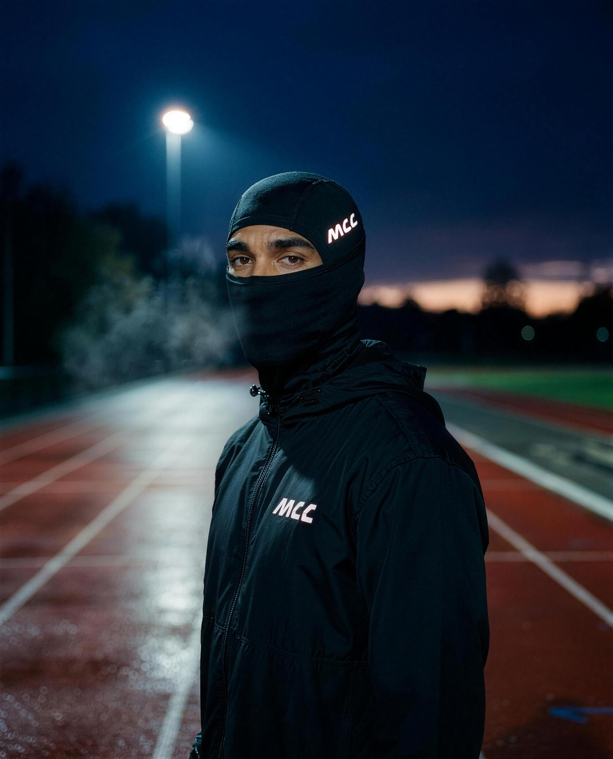 MCC 5-9 Active balaclava worn on a cold dark morning at the running track, reflective MCC wordmark catching the light